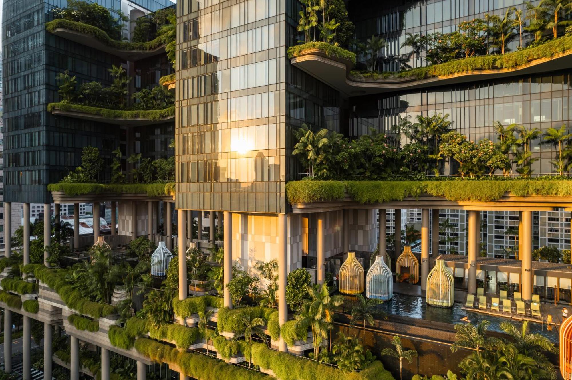 Parkroyal Collection Pickering, Singapura Luaran gambar The photo depicts a modern architectural structure featuring multiple levels with extensive greenery. The building is characterized by its glass facade, allowing natural light to filter in. It showcases various terraces and balconies adorned with pla